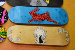 Photograph of 2 skateboards with artwork painted on them