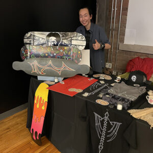 Photo of student at a table with skateboard artwork on it
